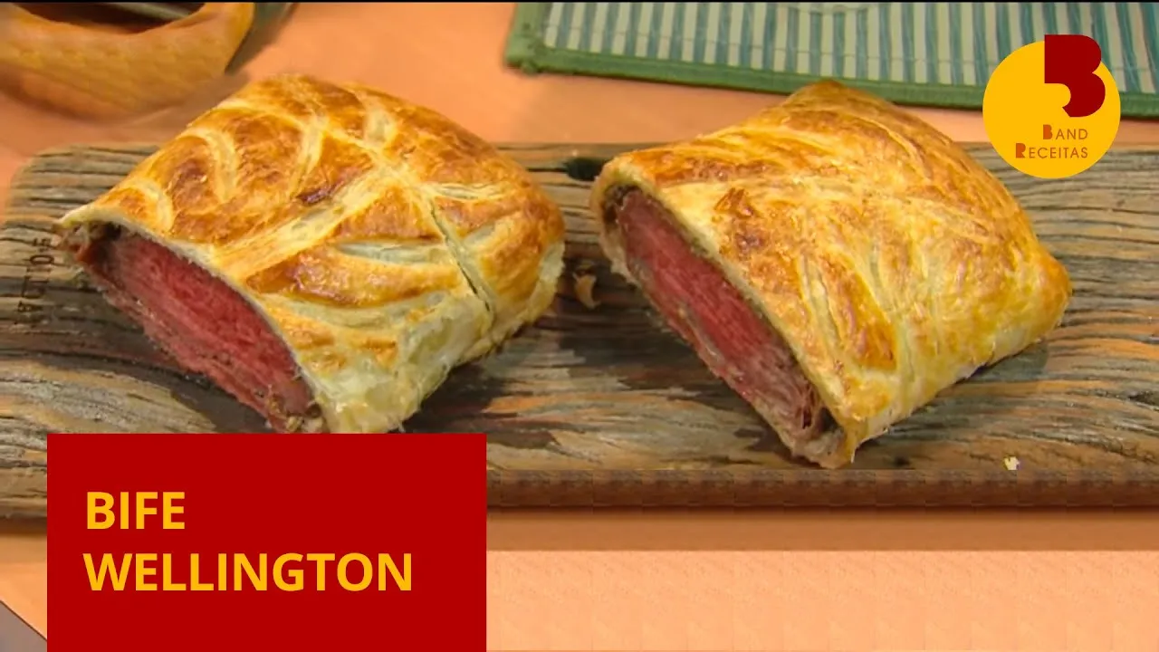 # Beef Wellington: Uma Delicada Obra-Prima Culinária ## Introdução O **Beef Wellington** é um dos pratos mais icônicos e refinados da gastronomia internacional. Com uma rica história e uma apresentação impressionante, essa receita consiste em um suculento filé mignon revestido com uma camada de patê, frequentemente patê de foie gras, e uma duxelles de cogumelos, tudo envolvido em uma massa folhada dourada e crocante. A combinação de sabores e texturas faz do Beef Wellington uma escolha popular para ocasiões especiais e celebrações. Neste artigo, exploraremos a história do Beef Wellington, discutiremos seus ingredientes principais e apresentaremos uma receita detalhada para você preparar esse clássico em sua própria cozinha. Além disso, abordaremos algumas dicas para garantir o sucesso do prato e variações que você pode experimentar. Ao final, incluiremos uma tabela nutricional e uma chamada para que você compartilhe essa deliciosa receita com seus amigos e familiares. ## História e Origem do Beef Wellington O **Beef Wellington** tem uma origem envolta em mistério e debate. Uma teoria popular sugere que o prato foi nomeado em homenagem ao Duque de Wellington, Arthur Wellesley, que derrotou Napoleão Bonaparte na Batalha de Waterloo em 1815. Outra versão propõe que o nome deriva de uma cidade na Nova Zelândia. Apesar dessas teorias, não há evidências concretas que provem sua origem. Independentemente de sua origem, o Beef Wellington ganhou fama mundial e se tornou um símbolo de sofisticação e culinária de alta qualidade. O prato é especialmente popular no Reino Unido e nos Estados Unidos, onde é frequentemente servido em restaurantes finos e em ocasiões especiais. ## Ingredientes Principais Os ingredientes de qualidade são fundamentais para o sucesso do **Beef Wellington**. Aqui estão os principais componentes necessários para preparar essa iguaria: ### Ingredientes - **Filé mignon**: 1 peça de aproximadamente 1 kg (de boa qualidade) - **Cogumelos**: 250g de cogumelos frescos (de boa qualidade), finamente picados - **Patê de foie gras** ou patê de fígado de galinha: 100g (opcional) - **Presunto de Parma**: 8 fatias finas - **Massa folhada**: 1 folha grande, descongelada se necessário - **Mostarda Dijon**: 2 colheres de sopa - **Gemas de ovo**: 1, batida para pincelar - **Azeite de oliva**: 2 colheres de sopa (pode ser óleo vegetal também) - **Cebola**: 1 pequena, bem picada - **Alho**: 2 dentes, bem picados - **Tomilho fresco**: 1 colher de chá - **Sal e pimenta**: A gosto ## Receita de Beef Wellington ### Preparação 1. **Preparação dos Ingredientes**: - Pré-aqueça o forno a 200°C. Tempere o filé mignon com sal e pimenta. Aqueça uma frigideira grande com azeite de oliva (ou óleo vegetal) e sele o filé por todos os lados, até dourar. Retire do fogo e pincele a carne com a mostarda Dijon. Deixe esfriar. 2. **Duxelles de Cogumelos**: - Na mesma frigideira, adicione um pouco mais de azeite e refogue a cebola e o alho (bem picados) até ficarem translúcidos. Adicione os cogumelos picados e o tomilho. Cozinhe em fogo médio até que a água dos cogumelos evapore completamente e a mistura esteja seca. Tempere com sal e pimenta. Deixe esfriar. 3. **Montagem**: - Sobre uma superfície plana, estenda um filme plástico. Coloque as fatias de presunto de Parma sobre o filme, formando uma camada. Espalhe a duxelles de cogumelos sobre o presunto. Coloque o filé mignon no centro e, com a ajuda do filme plástico, enrole tudo firmemente, formando um pacote. Leve à geladeira por 15 minutos para firmar. 4. **Envolvendo com Massa Folhada**: - Abra a massa folhada em uma superfície enfarinhada. Retire o pacote de carne da geladeira e desembrulhe. Coloque a carne sobre a massa folhada e enrole, selando as bordas com gemas de ovo batidas. Certifique-se de que a massa esteja bem fechada. Pincele toda a superfície com mais gema de ovo para obter uma cor dourada ao assar. 5. **Assamento**: - Coloque o Beef Wellington em uma assadeira e leve ao forno pré-aquecido. Asse por aproximadamente 25-30 minutos para um filé ao ponto, ou até que a massa folhada esteja dourada e crocante. Deixe descansar por 10 minutos antes de cortar. ### Rendimento Esta receita de **Beef Wellington** serve aproximadamente 6 pessoas. ### Tempo de Preparo - **Tempo de preparação:** 30 minutos - **Tempo de cozimento:** 30 minutos - **Tempo total:** 1 hora ## Dicas para o Sucesso do Beef Wellington 1. **Escolha do Filé**: Utilize um filé mignon de alta qualidade para garantir maciez e sabor. 2. **Selagem Perfeita**: Sele bem a carne para evitar que os sucos escorram durante o cozimento. 3. **Massa Folhada**: Certifique-se de que a massa folhada esteja bem fechada para evitar vazamentos de suco durante o cozimento. 4. **Tempo de Descanso**: Deixe o Beef Wellington descansar antes de cortar para que os sucos se redistribuam pela carne. ## Variações do Beef Wellington Embora a receita tradicional use filé mignon, existem várias variações para explorar: 1. **Beef Wellington de Salmão**: Substitui a carne por salmão, proporcionando uma opção mais leve. 2. **Vegetariano**: Use cogumelos Portobello ou outros vegetais como base, substituindo o filé mignon. 3. **Mini Beef Wellington**: Faça porções individuais usando pequenos pedaços de filé. ## Acompanhamentos para Beef Wellington O **Beef Wellington** é geralmente servido com acompanhamentos que complementam seu sabor rico e complexo. Algumas sugestões incluem: - **Purê de Batatas**: Cremoso e suave, combina perfeitamente com a carne. - **Legumes Salteados**: Como aspargos, cenouras ou vagens, para um toque de frescor. - **Molho de Vinho Tinto**: Um molho rico que adiciona profundidade ao prato. ## Tabela Nutricional | Nutriente | Quantidade por porção (aprox.) | |---------------------|--------------------------------| | Calorias | 600 | | Carboidratos | 35g | | Proteínas | 40g | | Gorduras | 35g | | Fibra Alimentar | 2g | | Açúcares | 3g | | Sódio | 700mg | | Cálcio | 4% do VD* | | Ferro | 25% do VD* | *VD: Valores Diários com base em uma dieta de 2.000 calorias. ## Conclusão O **Beef Wellington** é um prato que impressiona tanto pelo sabor quanto pela apresentação. Sua combinação de carne suculenta, cogumelos saborosos e massa folhada crocante o torna uma escolha clássica para celebrações e ocasiões especiais. Esperamos que esta receita e dicas tenham inspirado você a preparar essa iguaria em sua própria cozinha. --- ## Compartilhe essa receita Se você gostou dessa receita de **Beef Wellington**, compartilhe com seus amigos e familiares! Essa iguaria é perfeita para ser apreciada em momentos especiais e pode ser uma ótima adição ao seu repertório culinário. --- Beef Wellington